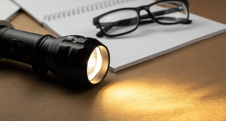 Poster - Office supplies with glowing flashlight on a brown recycled craft paper background