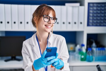 Poster - Young woman scientist smiling confident using smartphone at laboratory