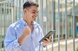 © Krakenimages.com - Young hispanic man smiling confident using touchpad at street