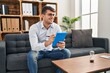 © Krakenimages.com - Young hispanic man psychologist smiling confident using touchpad at psychology clinic