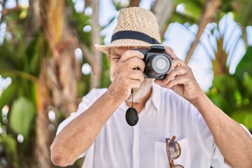 Canvas Print - Senior man smiling confident wearing summer hat using camera at park