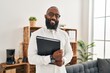© Krakenimages.com - Young african american man psychologist holding binder at psychology center