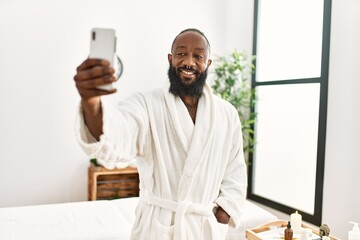 Poster - Young african american man smiling confident make selfie by the smartphone at beauty center