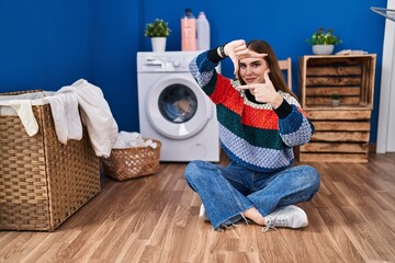 Canvas Print - Young hispanic girl doing laundry smiling making frame with hands and fingers with happy face. creativity and photography concept.