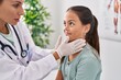 © Krakenimages.com - Woman and girl doctor and patient examining throat at clinic