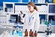 © Krakenimages.com - Young beautiful hispanic woman scientist holding bottle at laboratory