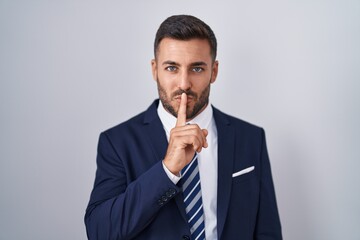 Sticker - Handsome hispanic man wearing suit and tie asking to be quiet with finger on lips. silence and secret concept.