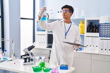 Canvas Print - Young hispanic man scientist holding test tube at laboratory