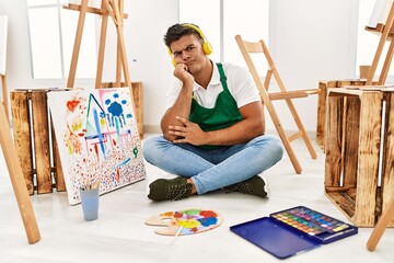 Sticker - Young hispanic man at art studio thinking looking tired and bored with depression problems with crossed arms.