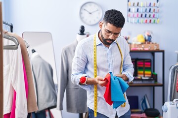 Sticker - Young arab man tailor holding cloths at tailor shop