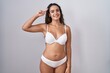 © Krakenimages.com - Young hispanic woman wearing white lingerie smiling pointing to head with one finger, great idea or thought, good memory