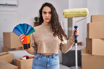 Sticker - Young brunette woman moving to a new home painting walls skeptic and nervous, frowning upset because of problem. negative person.