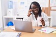 © Krakenimages.com - African american woman business worker talking on smartphone drinking coffee at office