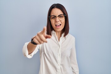 Sticker - Young hispanic woman standing over white background pointing displeased and frustrated to the camera, angry and furious with you