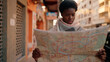 Young african american woman with serious expression holding city map at street