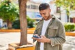 © Krakenimages.com - Young hispanic man smiling confident using smartphone at park