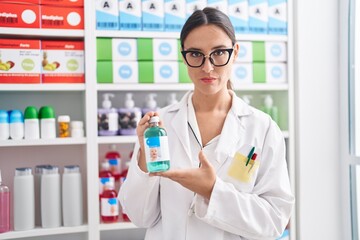 Sticker - Brunette woman working at pharmacy drugstore holding cough syrup skeptic and nervous, frowning upset because of problem. negative person.