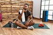 © Krakenimages.com - Young indian man sitting on training mat at the gym with hand on chin thinking about question, pensive expression. smiling with thoughtful face. doubt concept.