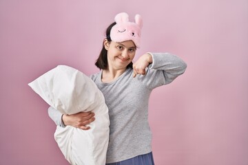 Canvas Print - Woman with down syndrome wearing sleeping mask hugging pillow looking confident with smile on face, pointing oneself with fingers proud and happy.