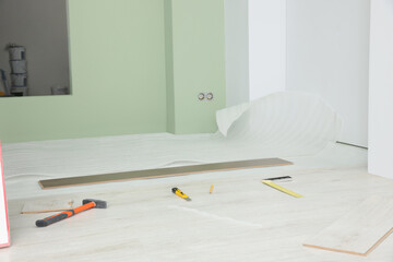 Sticker - Light room with unfinished laminate flooring and different tools