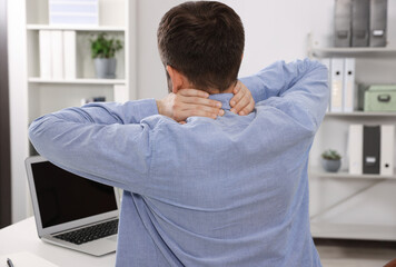 Poster - Man suffering from neck pain in office, back view