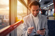 © Teodor Lazarev - Handsome man on a bus, looking at his phone, browsing social media while commuting