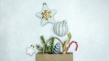 Sticker - christmas tree decorations with fir branch and cone. christmas shopping bag on silver background.