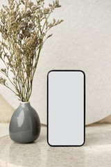 Poster - mockup blank screen mobile phone with flower in vase on white stone table