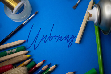 Poster - Overhead shot of school supplies with Unboxing text. Brushes, pencils, artistic tools. Art And Craft Work Tools.