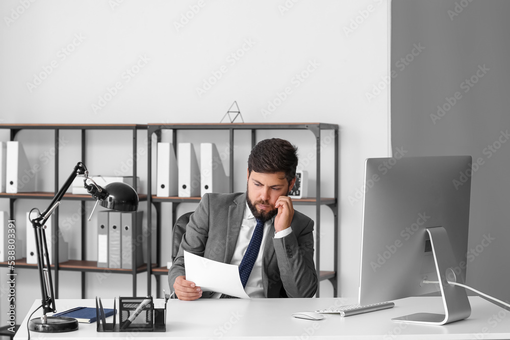 Sad young man reading order for his dismissal in office