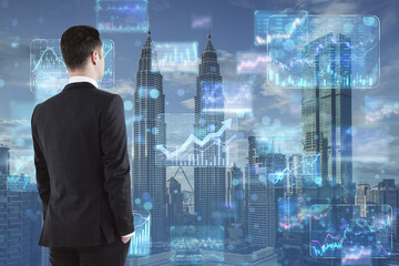 Sticker - Stock market and investing concept with businessman back view looking at digital screens with financial chart diagrams, arrows and graphs on city skyscrapers background