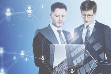 Poster - businessmen using laptop computer with abstract glowing people and light bulb network on blurry background. Networking, teamwork, internet communication and social media concept. Double exposure.