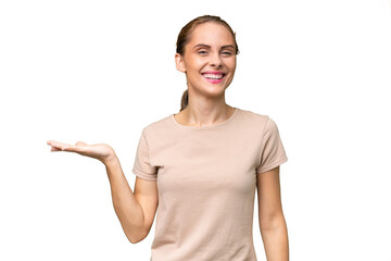 Young caucasian woman over isolated background holding copyspace imaginary on the palm to insert an ad