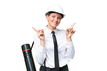 Wall Mural - Young architect caucasian woman with helmet and holding blueprints over isolated background pointing finger to the laterals and happy