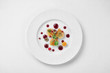 Fototapeta  - Foie gras with apple confit and berry sauce in a white plate on a white background. Close-up, selective focus.