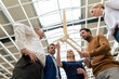 © Westend61 - Smiling businesswoman with colleagues discussing over wind turbine model at industry