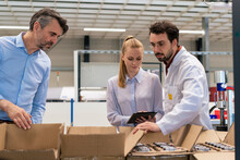 Businesswoman With Colleagues Taking Inventory At Warehouse