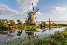 Netherlands, South Holland, Kinderdijk, Countryside River And Historic Windmills