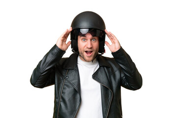 Young caucasian man with a motorcycle helmet isolated on green chroma background with surprise expression