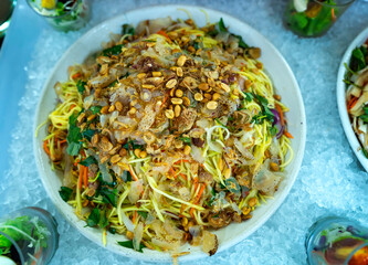 Salad of meat, jellyfish mixed with vegetables garnished with fried peanuts and onions on a plate for restaurant buffet