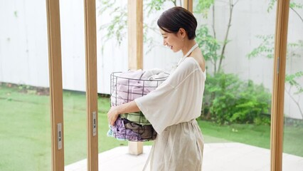 Leinwandbilder - 洗濯カゴを持つミドル女性
