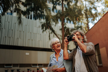 Wall Mural - Senior tourists taking pictures outside.