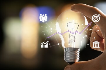 Poster - Businessman hand holding light bulb for ideas concept