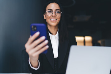 Wall Mural - Smiling woman using mobile phone in office