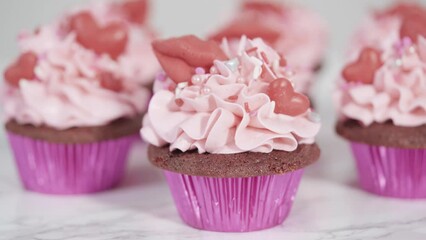 Wall Mural - Red velvet cupcakes with pink Italian buttercream frosting and decorates with heart and kiss shaped red chocolates.