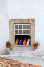 Porcelain Figurines Of Colorful Cats Sitting  In A Window