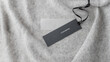 © BarTa - Dark paper tag with word cashmere on light grey luxury pure cashmere  background.