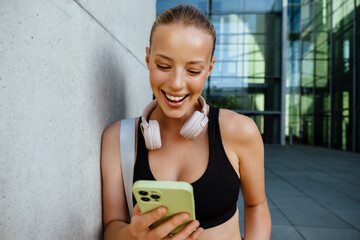 Wall Mural - White young woman using mobile phone after yoga practice