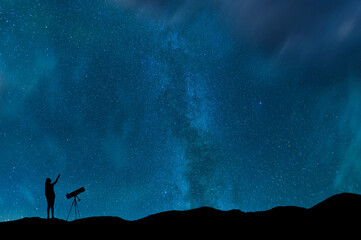 Wall Mural - Girl silhouette stands on the hill with telescope on and looks on the  milky way galaxy. Dark starry night.