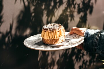 Sticker - Hand holding a plate with Paris-Brest dessert